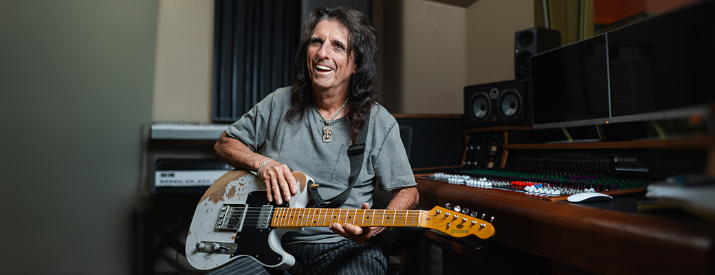 Image of Alice Cooper with his guitar and talking about his hearing loss and Starkey hearing aids
